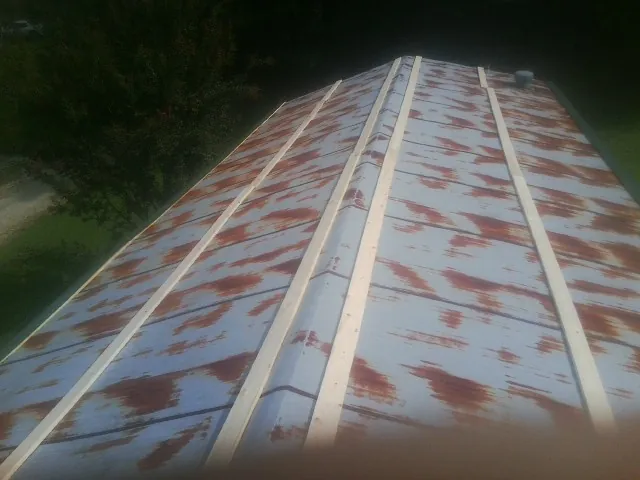 Rusted metal roof panels with new wood purlins before replacement — Storm Damage Roof Repair in Plantersville by Roofing Brothers