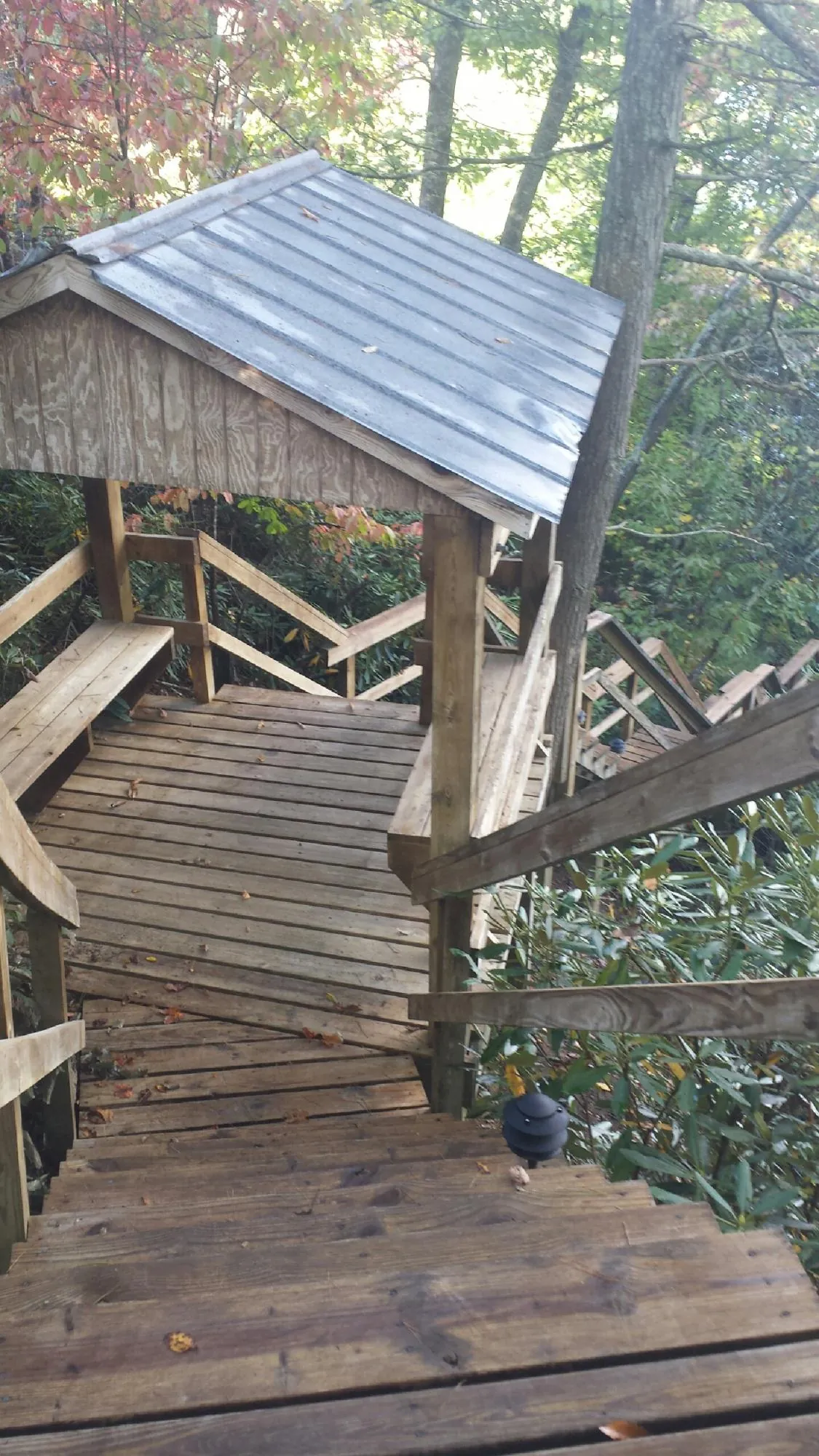 Metal roofed shelter over wooden steps on a wooded walkway — Skylight Repair & Installation work by our crew in Plantersville